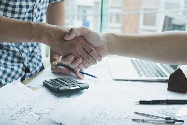 Architect and customer shaking hands at workplace. Engineer hand