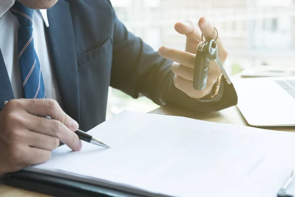 Hombre de negocios firmar contrato de venta con la llave del coche en la oficina. ownershi — Foto de Stock