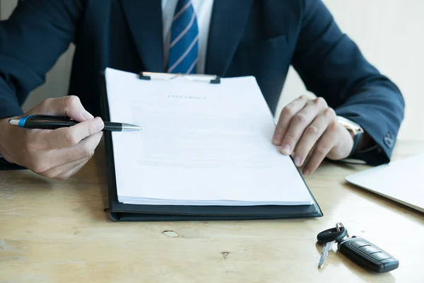 Hombre de negocios presente firma contrato de venta con llave de coche a custo — Foto de Stock