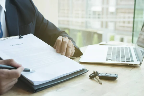 Uomo d'affari presente firma contratto di vendita con chiave auto a custo — Foto Stock