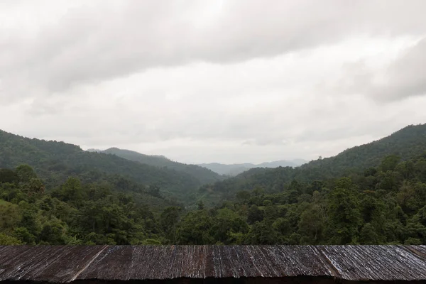 Лес, горный ландшафт, облачное небо с деревянным столом для монта — стоковое фото