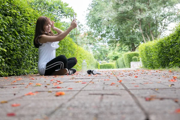 Asijské žena se sluchátky. mladá žena hospodářství mobilní smart — Stock fotografie