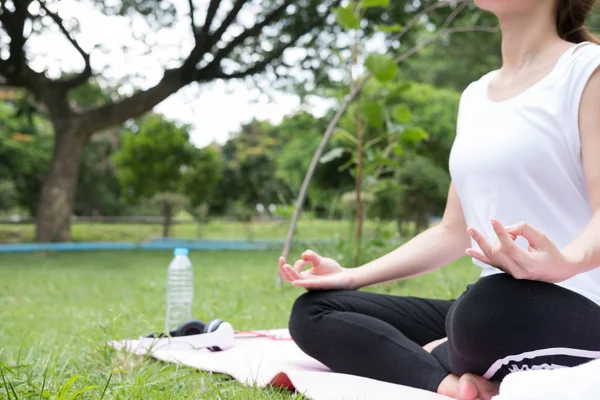 Yogada genel park açık havada. Asyalı kadın lotus bulunduğu oturur