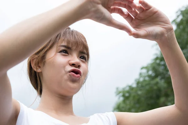 Молода жінка робить серцевий жест з пальцями. азіатська дівчина — стокове фото
