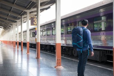 tren istasyonunda platformda ayakta sırt çantası olan Asya adam. b