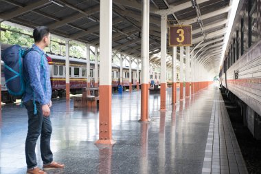 tren istasyonunda platformda ayakta sırt çantası olan Asya adam. b