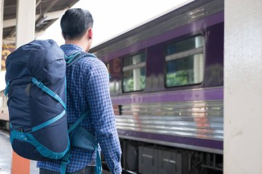 tren istasyonunda platformda ayakta sırt çantası olan Asya adam. b