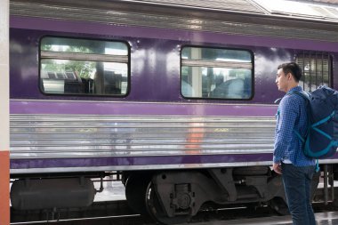 tren istasyonunda platformda ayakta sırt çantası olan Asya adam. b