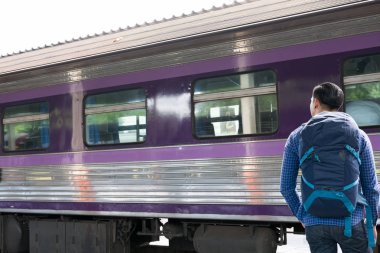 tren istasyonunda platformda ayakta sırt çantası olan Asya adam. b