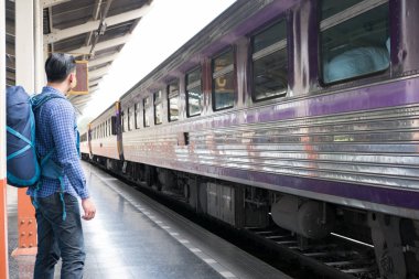 tren istasyonunda platformda ayakta sırt çantası olan Asya adam. b