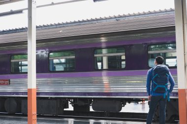 tren istasyonunda platformda ayakta sırt çantası olan Asya adam. b