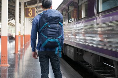 tren istasyonunda platformda ayakta sırt çantası olan Asya adam. b