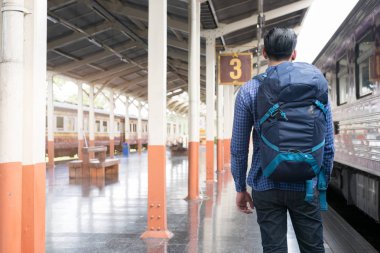 tren istasyonunda platformda ayakta sırt çantası olan Asya adam. b