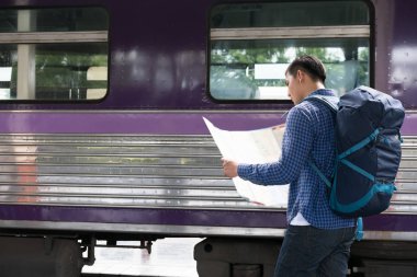 tren istasyonunda platformda ayakta sırt çantası olan Asya adam. b