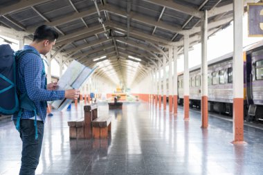 tren istasyonunda platformda ayakta sırt çantası olan Asya adam. b