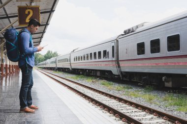 tren istasyonunda platformda ayakta sırt çantası olan Asya adam. b