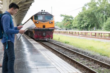 tren istasyonunda platformda ayakta sırt çantası olan Asya adam. b