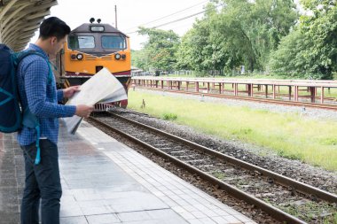 tren istasyonunda platformda ayakta sırt çantası olan Asya adam. b