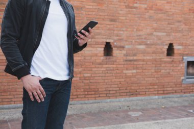 siyah ceket ve nea ayakta kot giyen genç Asyalı adam