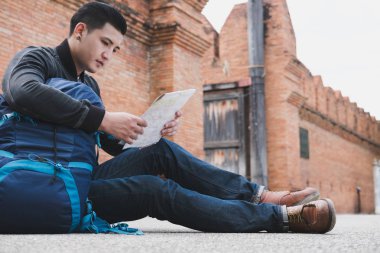 Genç Gezgin okuma harita. Asya adam siyah ceket ve b