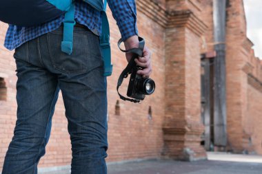 mavi gömlek ve kamera ve bac ile kot giyen genç Asyalı adam