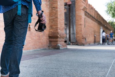 mavi gömlek ve kamera ve bac ile kot giyen genç Asyalı adam