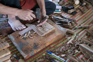 Zanaatkar, tahtaya geleneksel levrek kabartması oymak için oyuk kullanır.