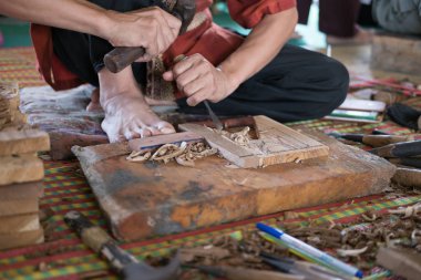 Zanaatkar, tahtaya geleneksel levrek kabartması oymak için oyuk kullanır.
