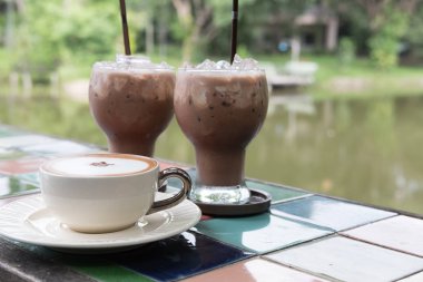 sıcak cappuccino kahve Kupası ve buzlu çikolata kakao içmek 