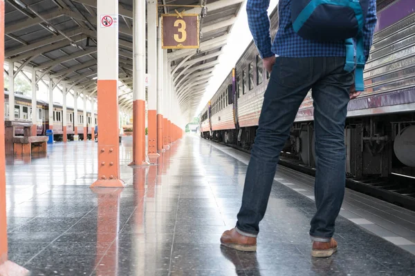Asiatisk man med ryggsäck står på plattformen vid tågstationen. b — Stockfoto