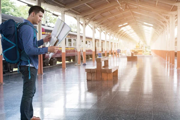 Ein Mann mit Rucksack steht auf dem Bahnsteig am Bahnhof. b — Stockfoto