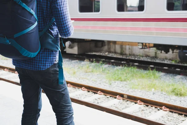 Asiático homem com mochila de pé na plataforma na estação de trem. b) — Fotografia de Stock