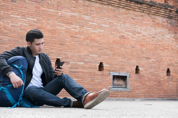 stock image young traveler, asian man wearing black jacket and blue jeans si