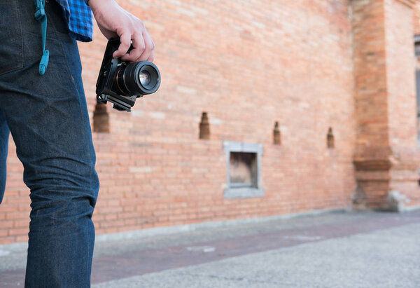 молодой азиат в синей рубашке и джинсах с камерой и баком
