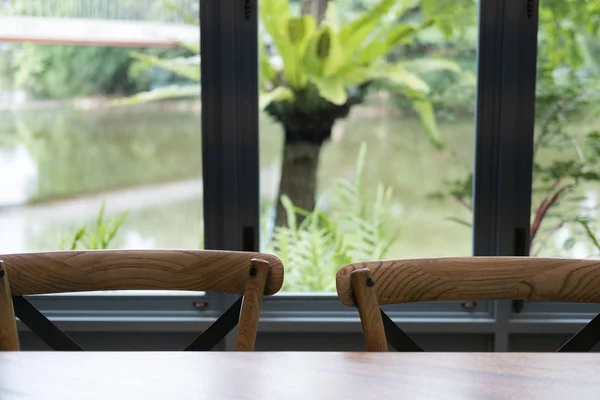 Tafel en stoel in de eetkamer naast venster met meer hout en — Stockfoto