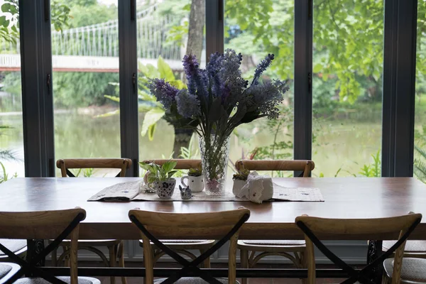 Mesa de madera y silla en el comedor junto a la ventana con el lago y — Foto de Stock