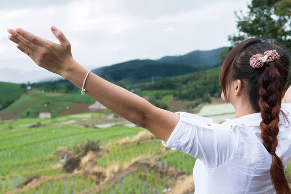 Vrouw haar hand opsteken met geluk op groene rijst veld op terra — Stockfoto