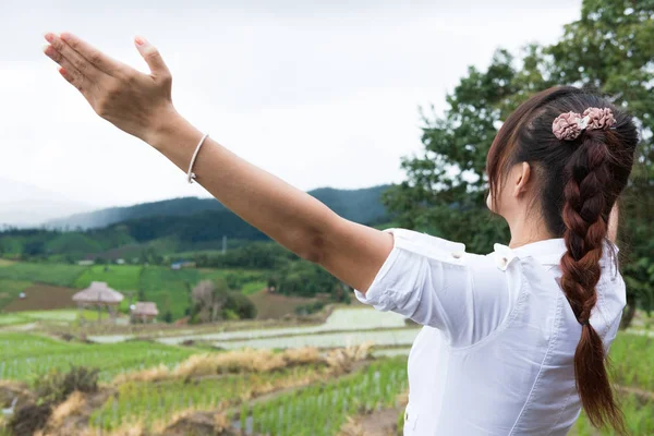 Vrouw haar hand opsteken met geluk op groene rijst veld op terra — Stockfoto
