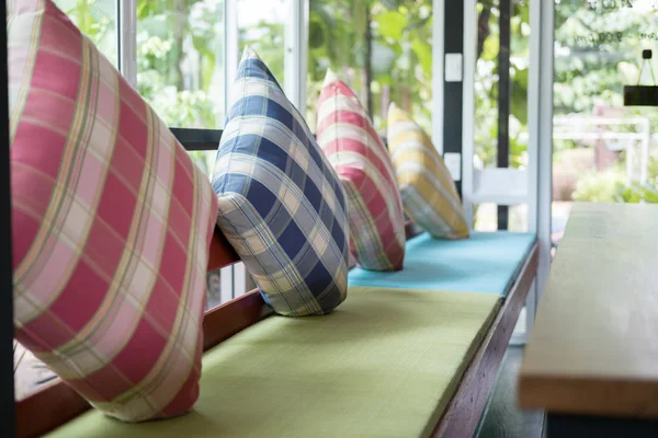 Travesseiro colorido na cadeira de madeira com almofada de tecido no restaurante — Fotografia de Stock