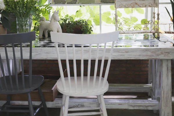 Cadeira branca e preta com mesa de madeira perto da janela com lea verde — Fotografia de Stock