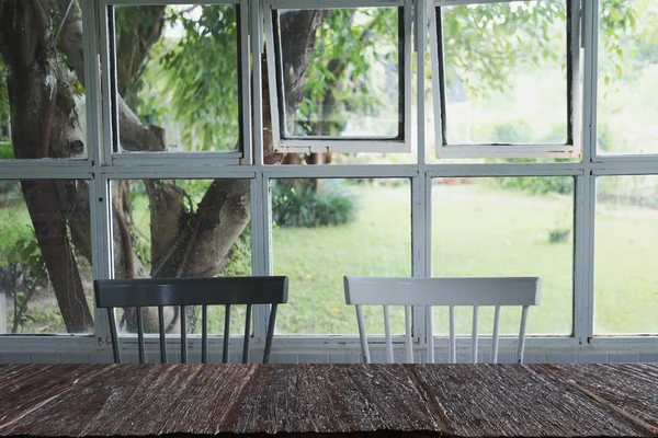 Sedia bianca e nera vicino alla finestra con sfondo giardino con wo — Foto Stock