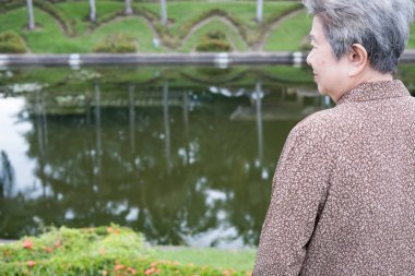 bahçede duran Asya yaşlı kadın. yaşlı üst düzey kadın dinlenme