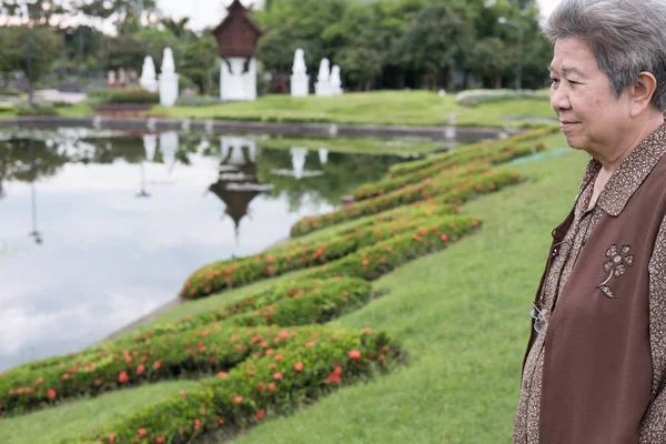 Mujer mayor asiática de pie en el jardín. anciano mayor reposo femenino — Foto de Stock