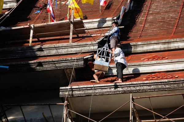 Roofer montaje de azulejos a la parte superior del techo del templo sin terminar — Foto de Stock