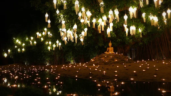 Kaarsen licht aan gouden Boeddha beeld met mooie water reflectie — Stockfoto