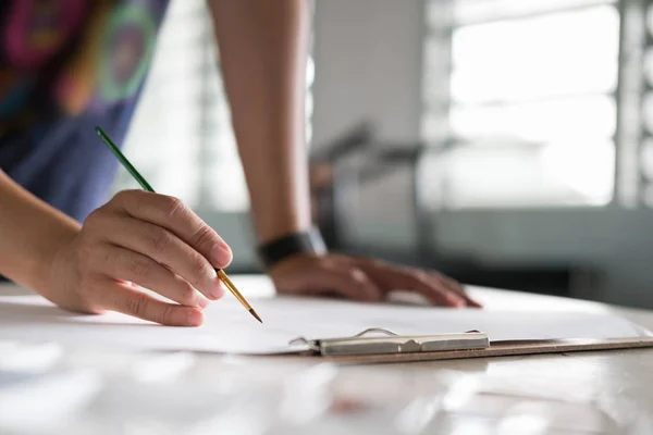 Artist painting picture on paper at studio. woman holding brush — Stock Photo, Image