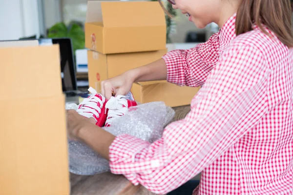 Poner en marcha zapatos de embalaje de propietarios de pequeñas empresas en la caja en workpl — Foto de Stock