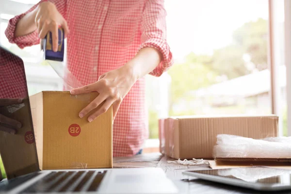 Poner en marcha el propietario de la pequeña empresa embalaje caja de cartón en el lugar de trabajo — Foto de Stock
