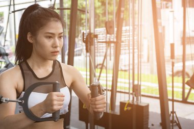 genç kadın ile makine fitness merkezinde egzersiz yürütmek. FEM