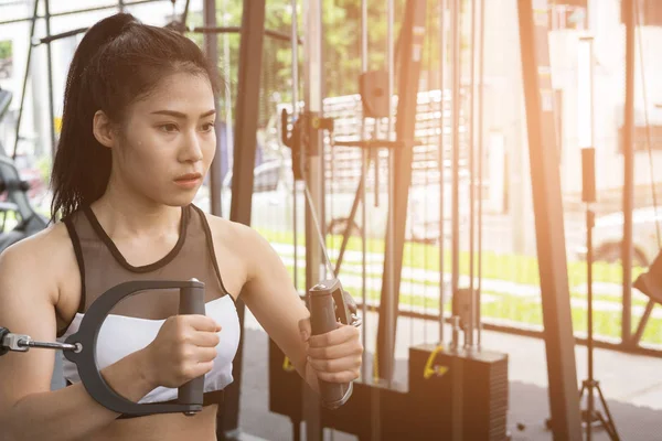 genç kadın ile makine fitness merkezinde egzersiz yürütmek. FEM